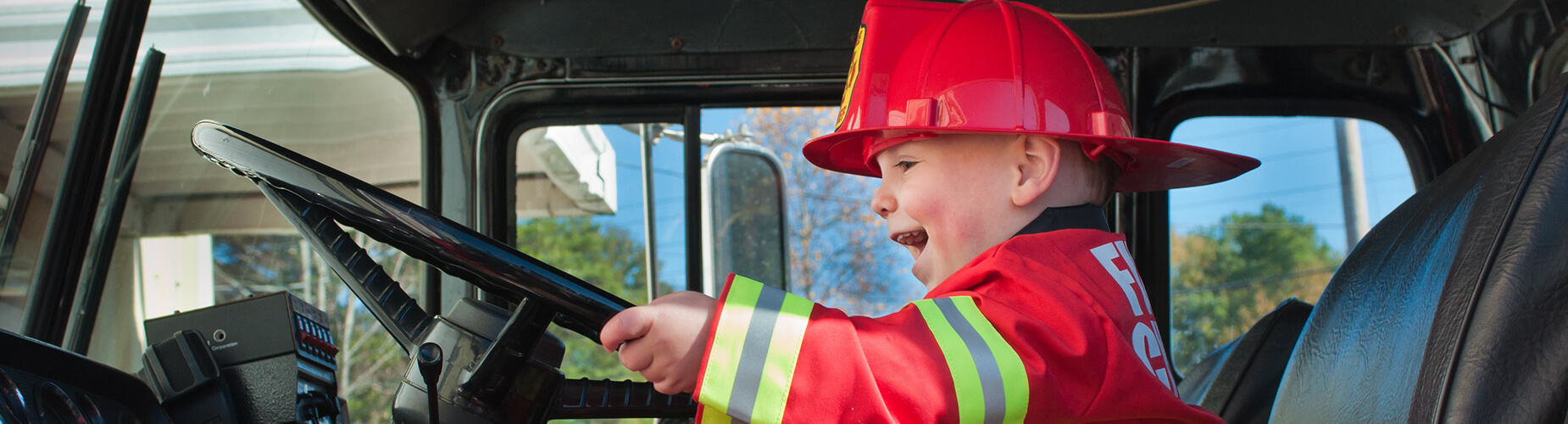 Feuerwehrförderung Kind im Feuerwehrauto