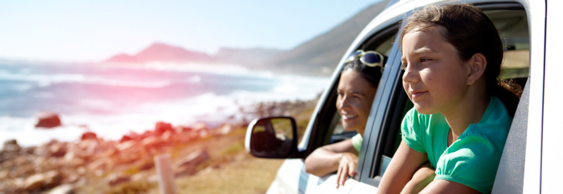 Auslandschadenschutz - Familie schaut aus dem Autofenster auf das Meer