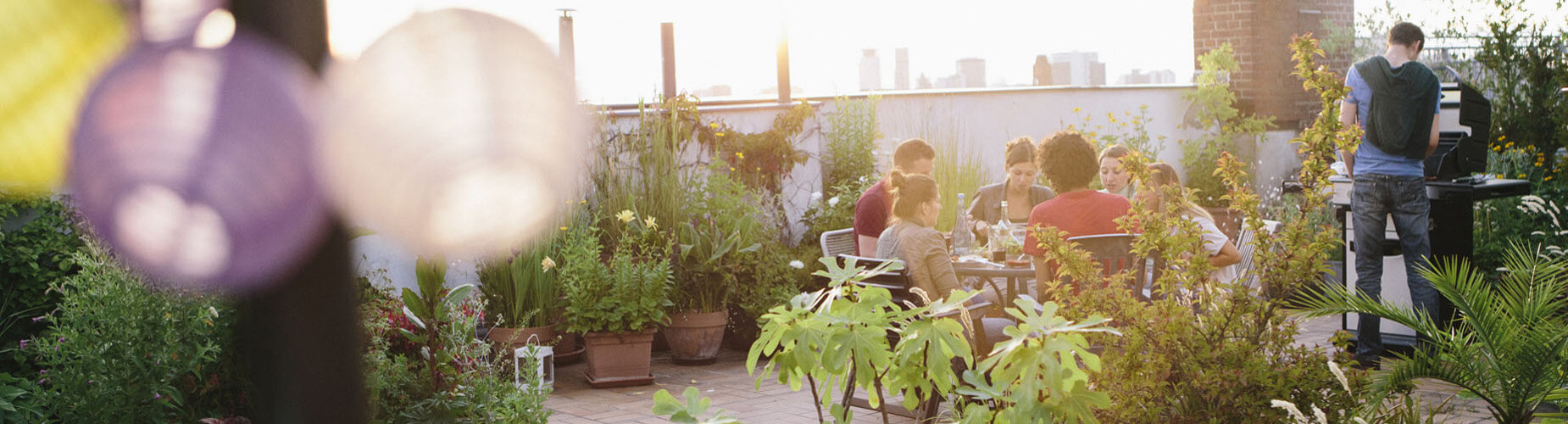 Freunde auf der Dachterrasse beim Grillen