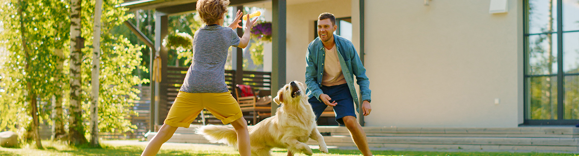 Haus- und Grundbesitzerhaftpflichtversicherung - Familie spielt mit Hund