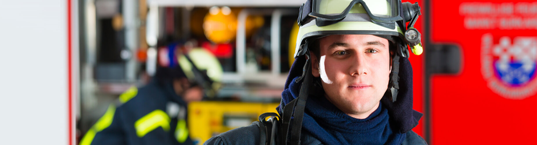 Feuerwehrförderung Feuerwehrmann vor dem Feuerwehrauto